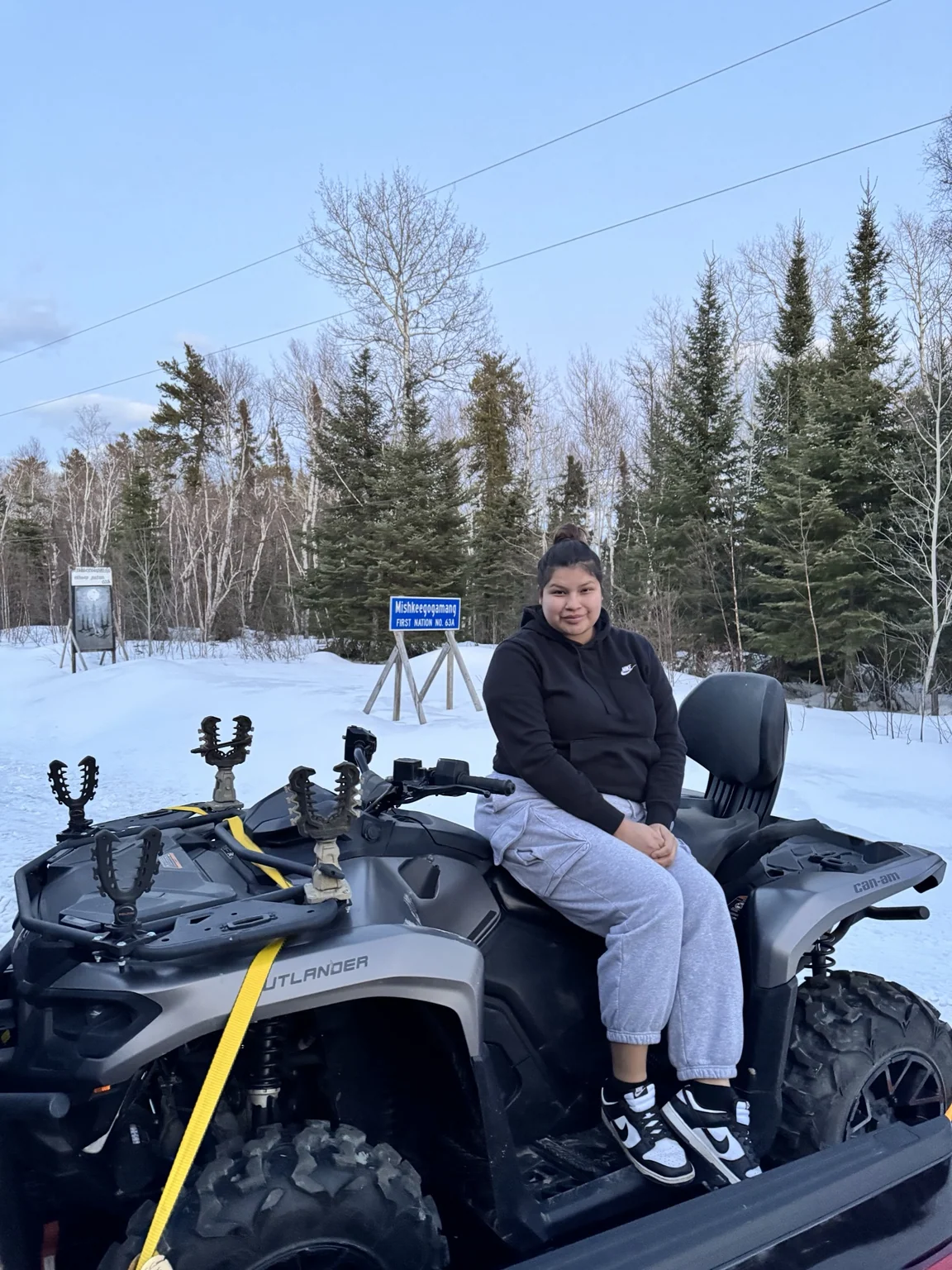 Customer beside an ATV in snow