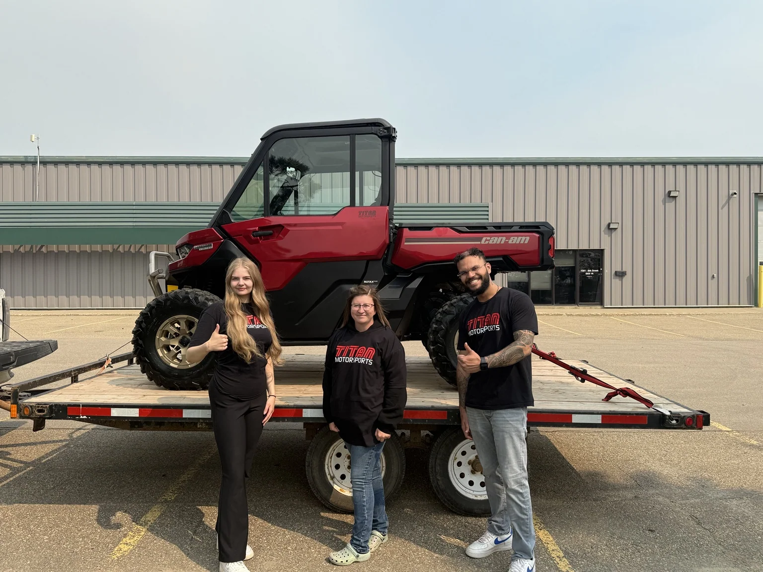 Customers beside a side-by-side on a trailer