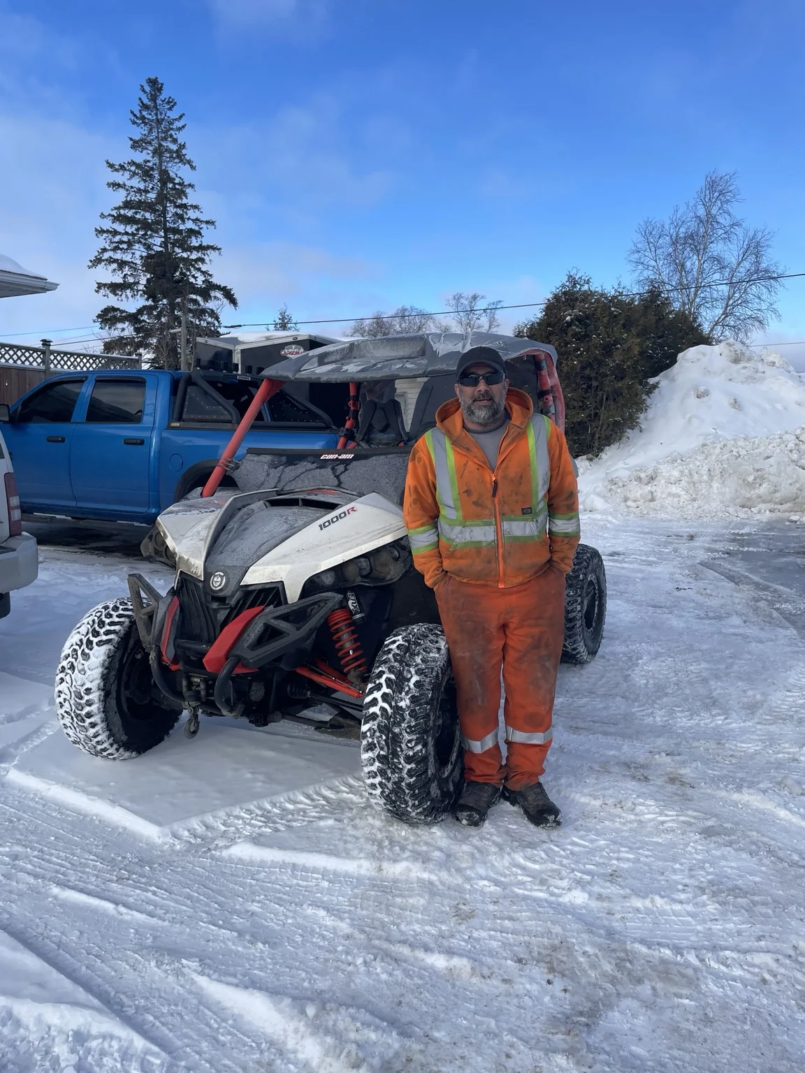 Customer beside a white side-by-side in snow