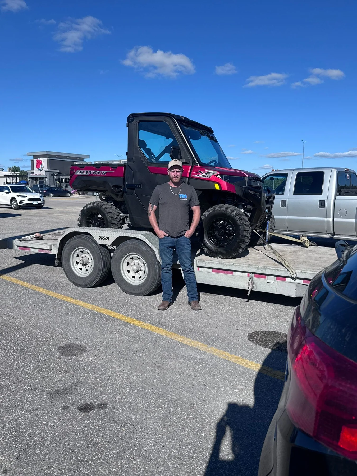 Customer beside a side-by-side on a trailer