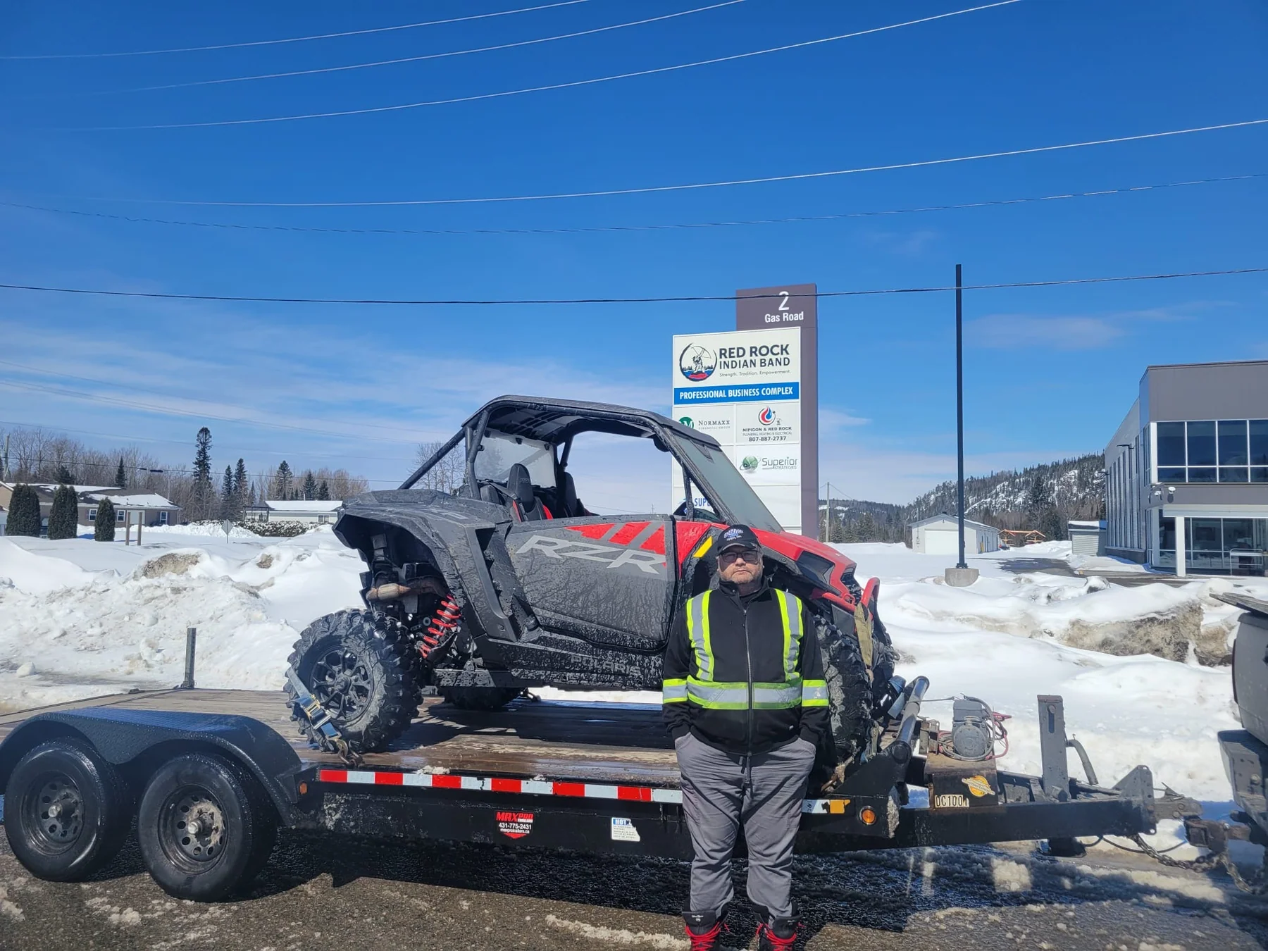 Customer beside a side-by-side on a trailer