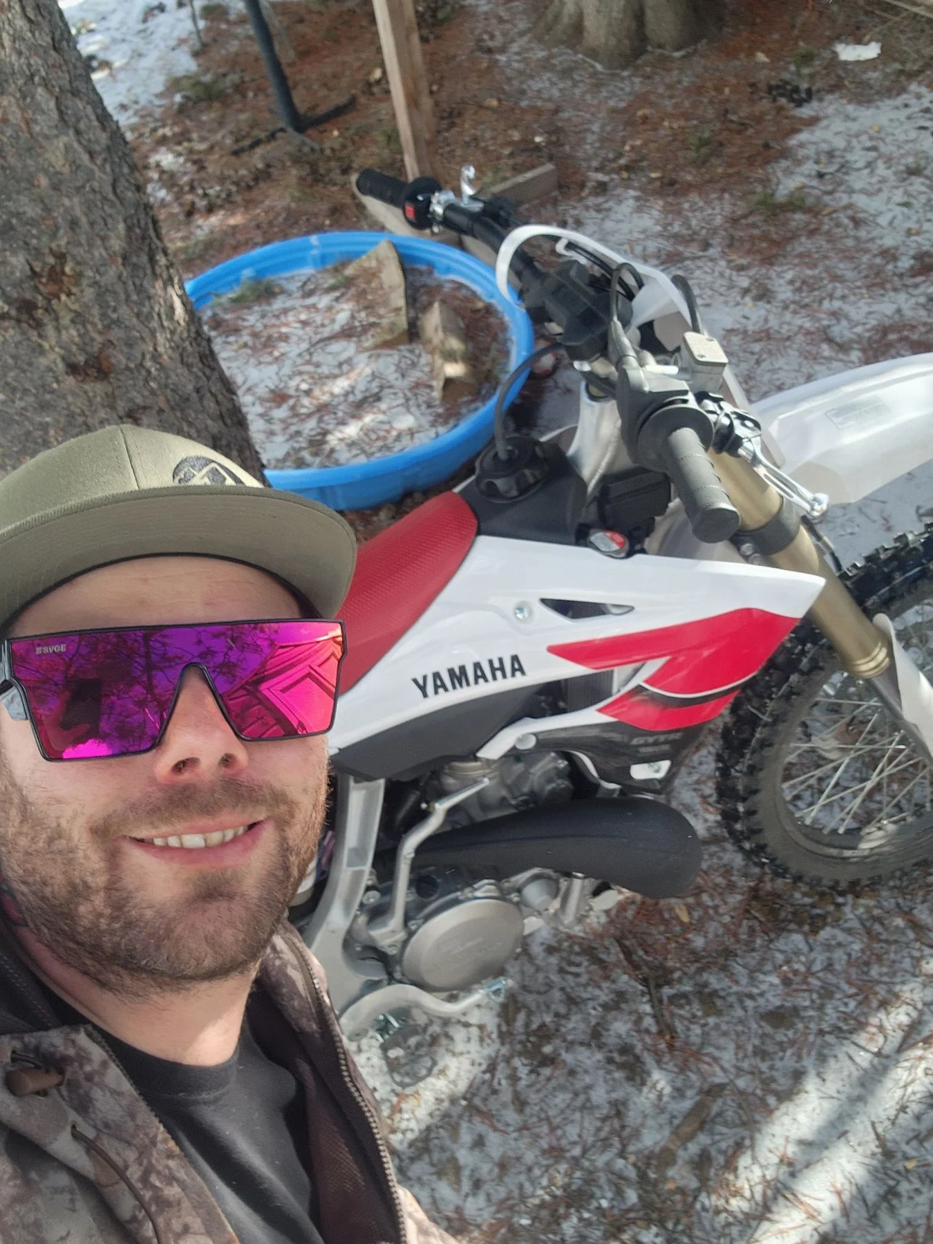 Rider selfie beside a Yamaha dirt bike