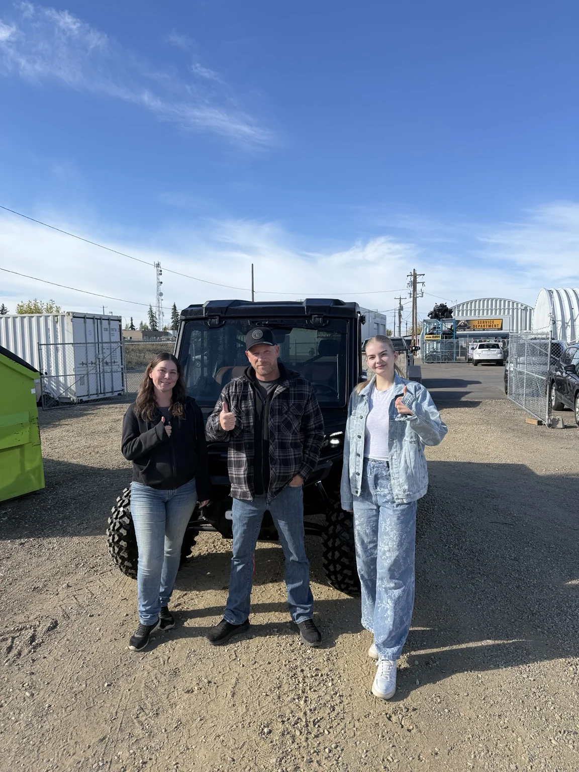 Customers posing with a side-by-side outdoors