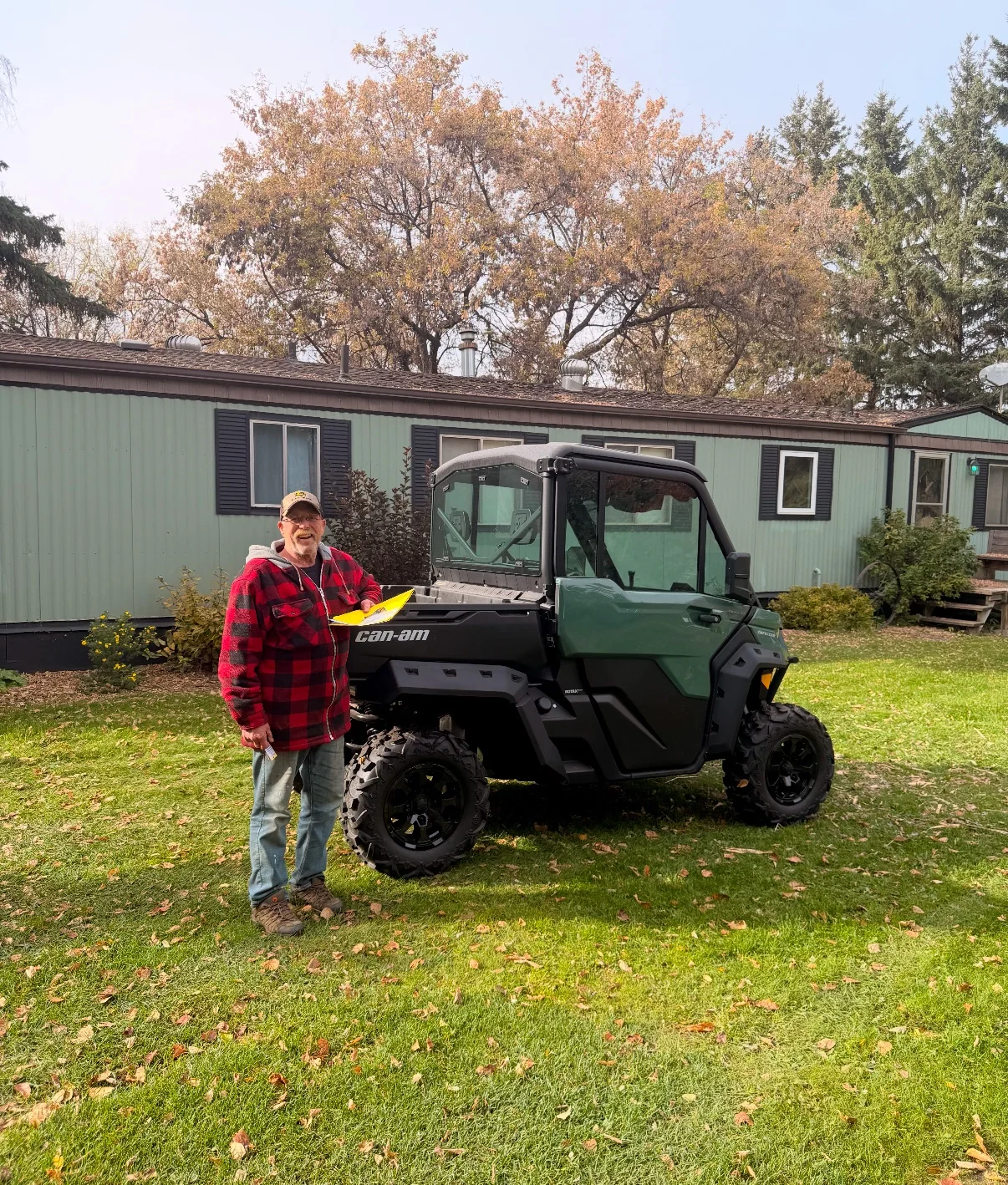 Customer beside an ATV near a home