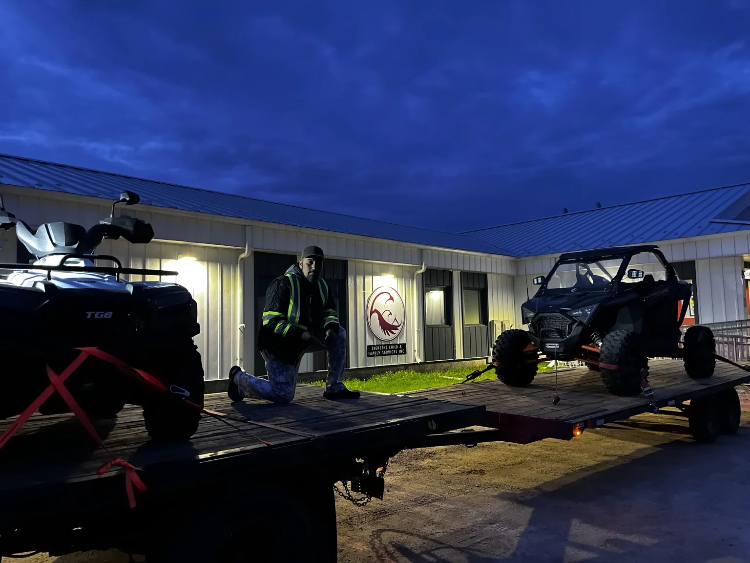 Customer with off-road vehicles on a trailer at night