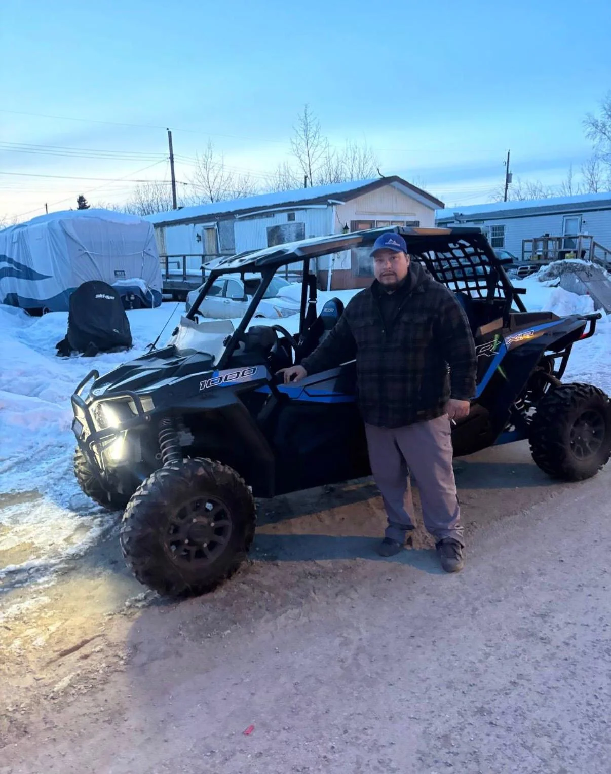 Customer beside a side-by-side on a snowy driveway