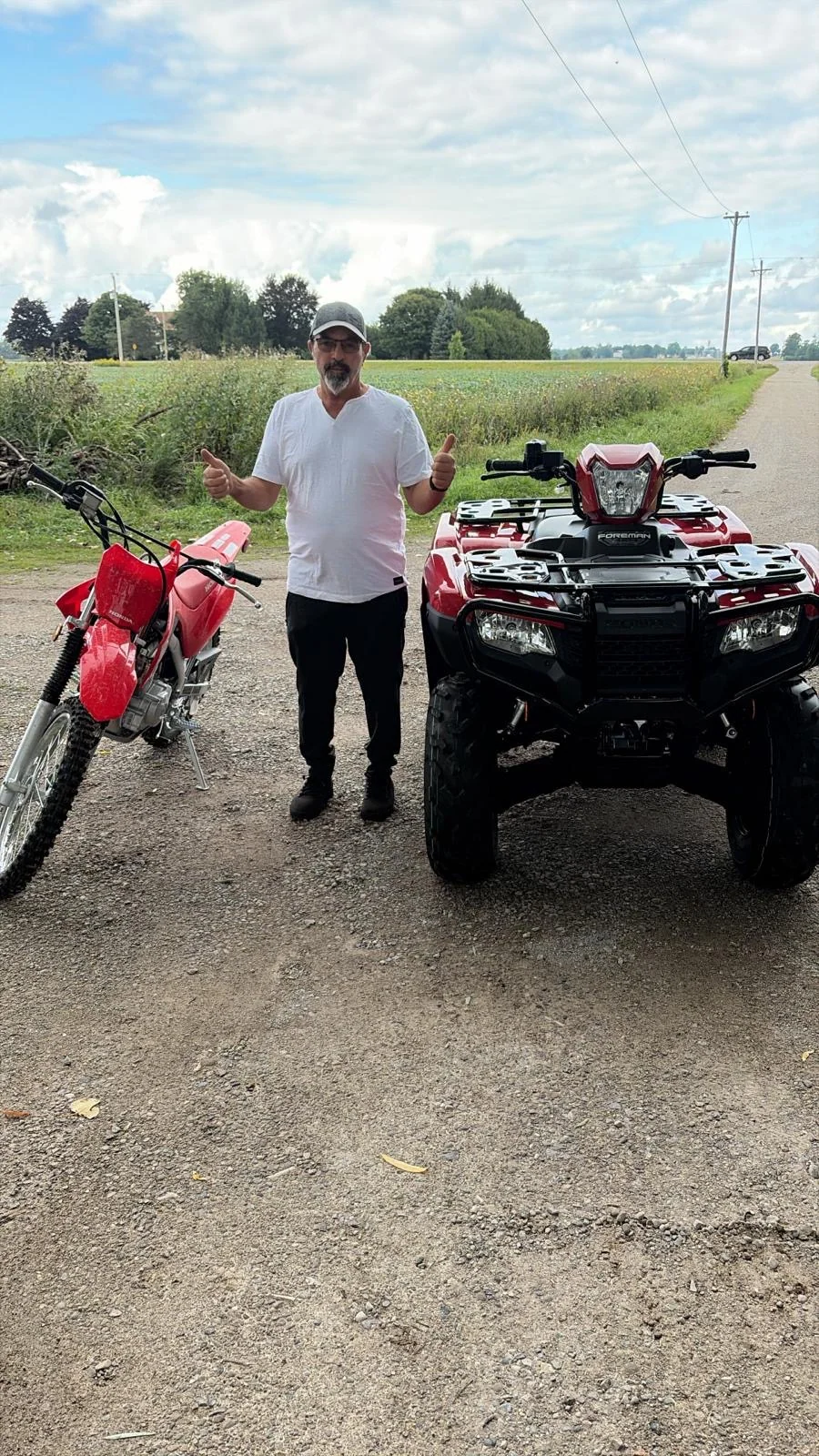 Customer beside an ATV and dirt bike